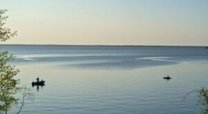 anglers in boats on Lake Winnipeg. Golden sky in background