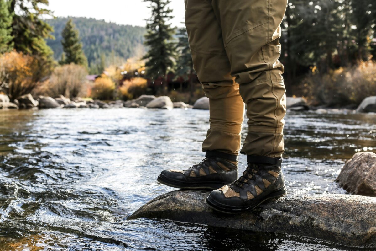 Feet of a man fly fishing somewhere in Black Hills. Photo by Taylor Grote